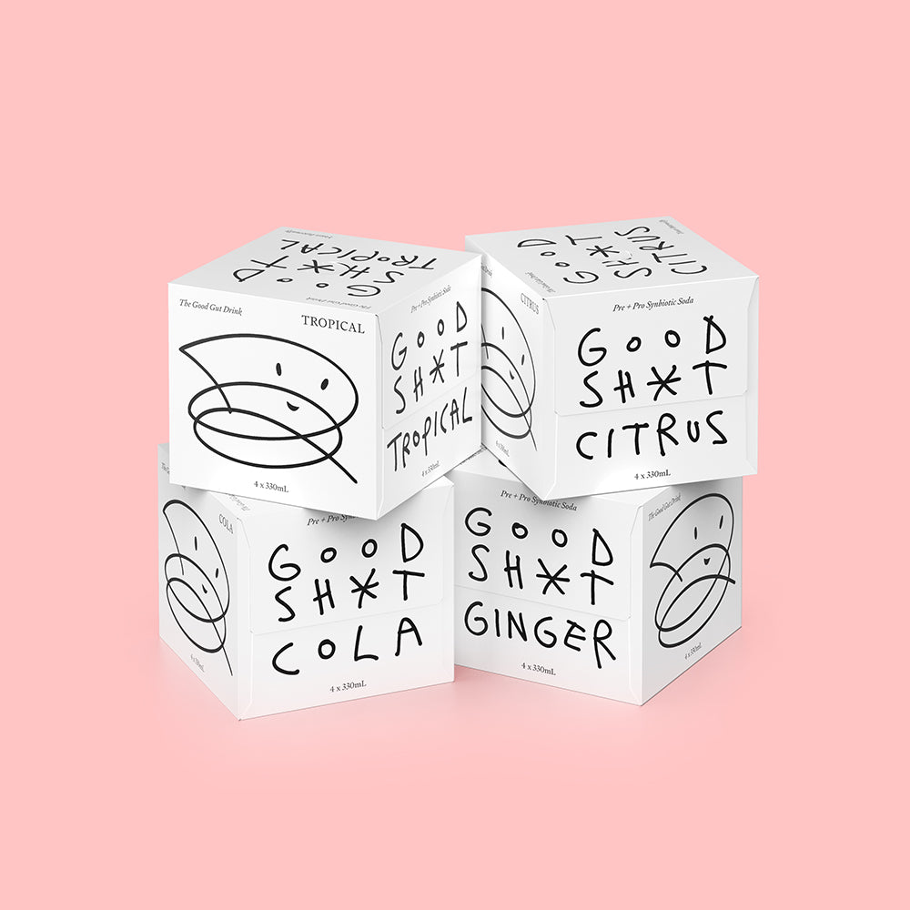 A stack of four 4 pack boxes of Good Shit pre + probiotic soda. One box each of citrus, cola, ginger and tropical flavours