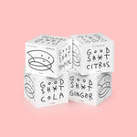 A stack of four 4 pack boxes of Good Shit pre + probiotic soda. One box each of citrus, cola, ginger and tropical flavours